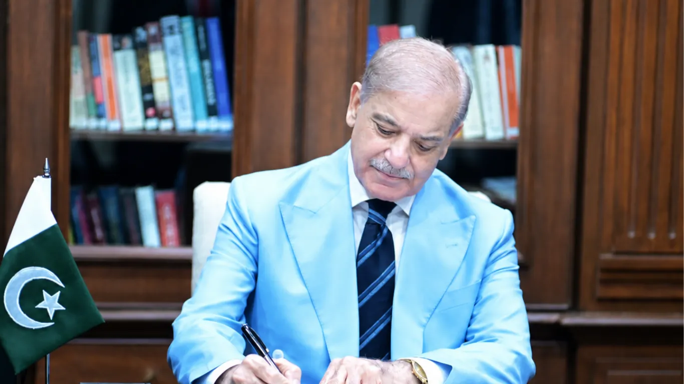 Pakistan Prime Minister Shehbaz Sharif signs the Islamabad MOU at his desk beside the Pakistani flag on June 17, 2026